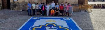 Participantes colocando sal teñida durante la elaboración de la alfombra por el Corpus Christi en Montijo.